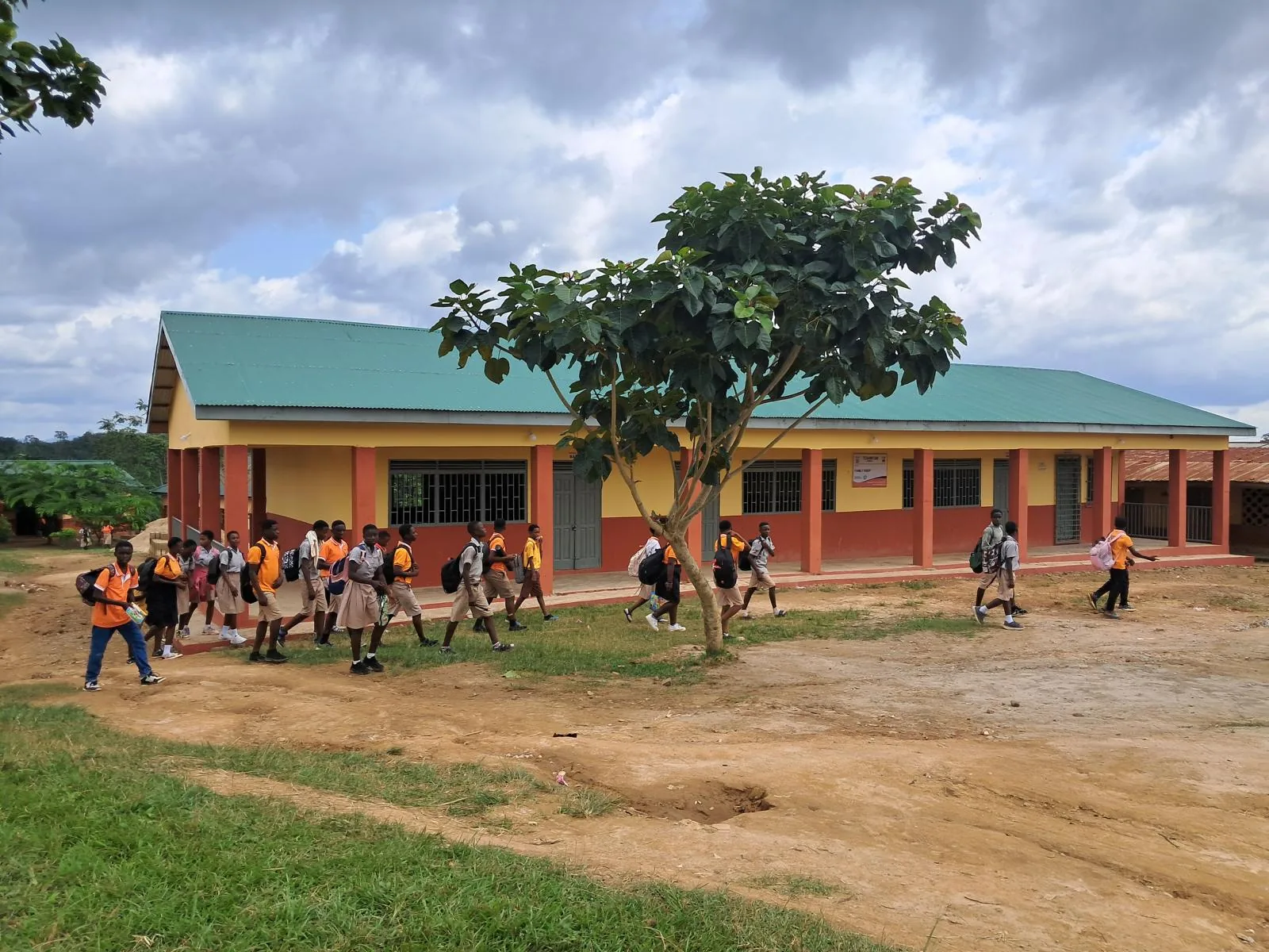 Fertige Fly-&-Help-Schule in Toamfom, Ghana, mit Schulkindern auf dem Hof